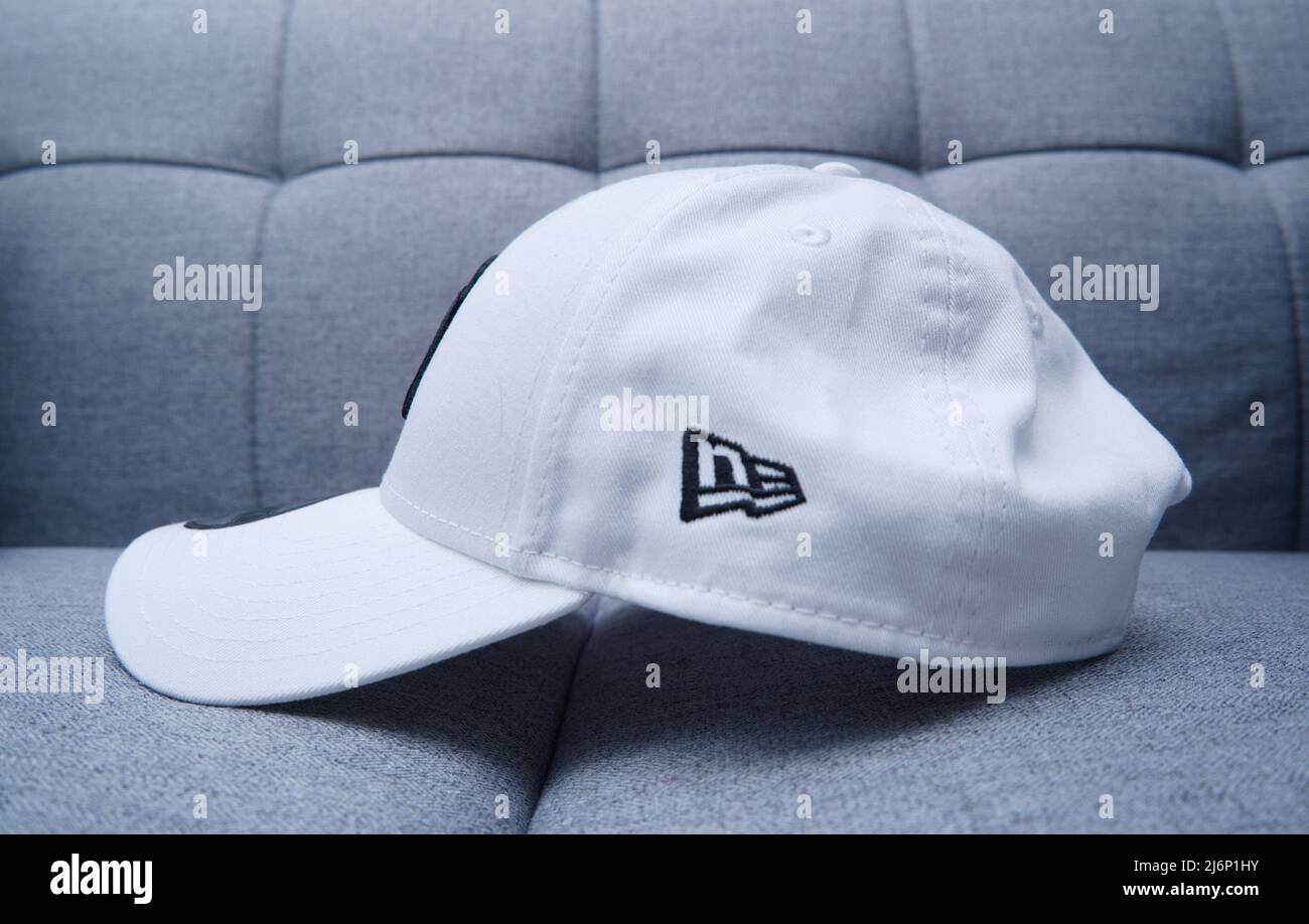 Hong Kong - 3 Maggio, 2022: Cappellino da baseball con attacco SnapBack New York bianco per uomini sul divano grigio. Con ricamo Chunky e adesivo. Foto Stock