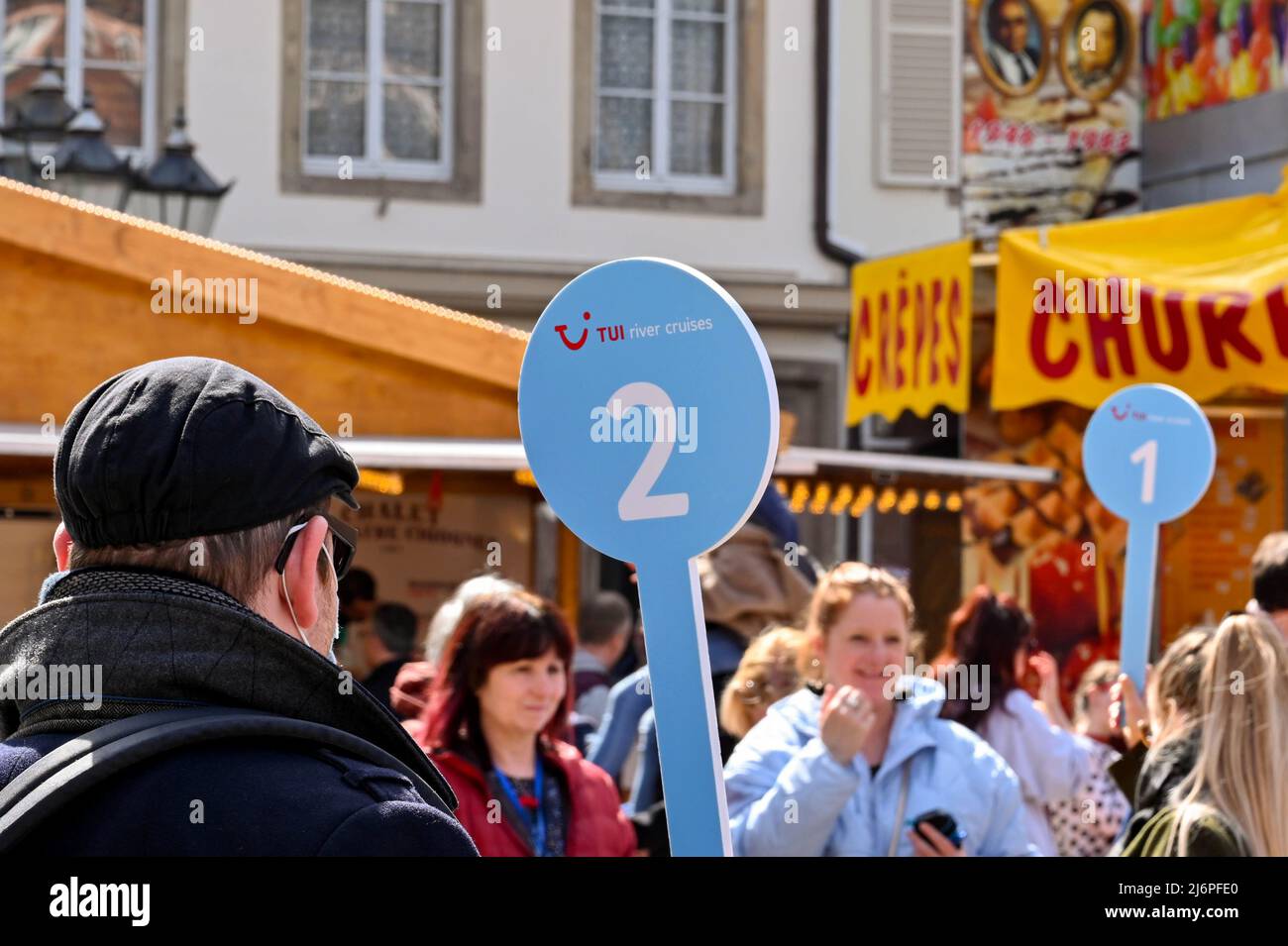 Strasburgo, Francia - Aprile 2022: Guida turistica che lavora per TUI River Cruises tenendo una bandiera per guidare il gruppo di turisti in giro per la città Foto Stock