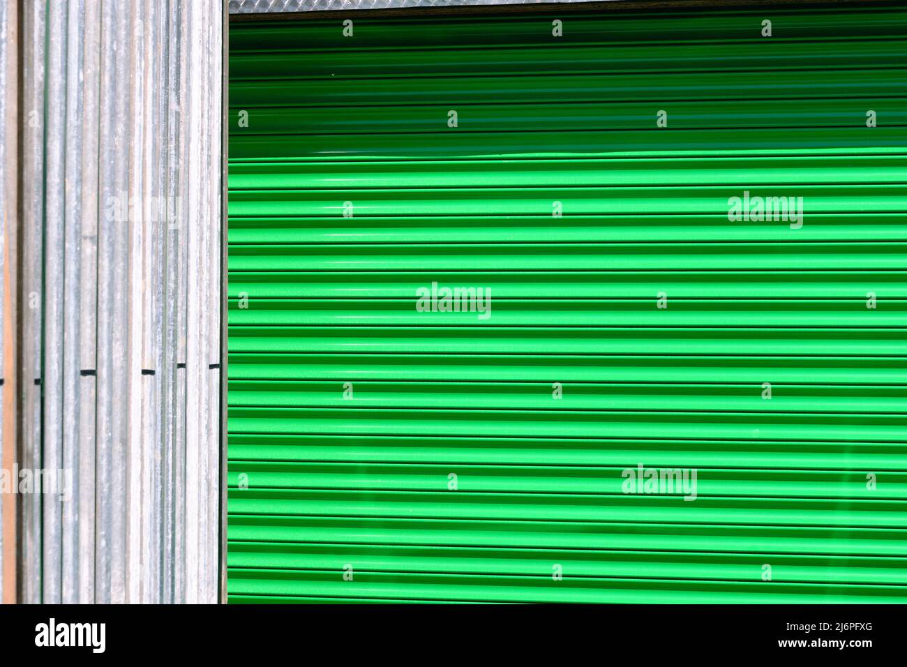 Un disegno astratto verde brillante creato da casseforme in metallo ondulato Foto Stock