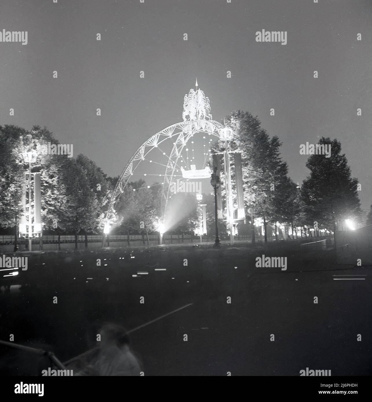 1953, storica, Queens Coronation, lungo il Mall luci decorative, tra cui uno dei grandi archi di incoronazione, che sono stati costruiti per celebrare l'incoronazione della regina Elisabetta II al trono, Londra, Inghilterra, Regno Unito. Realizzati in tubolare d'acciaio, vi erano quattro arcate a coronazione situate lungo il Mall. Foto Stock