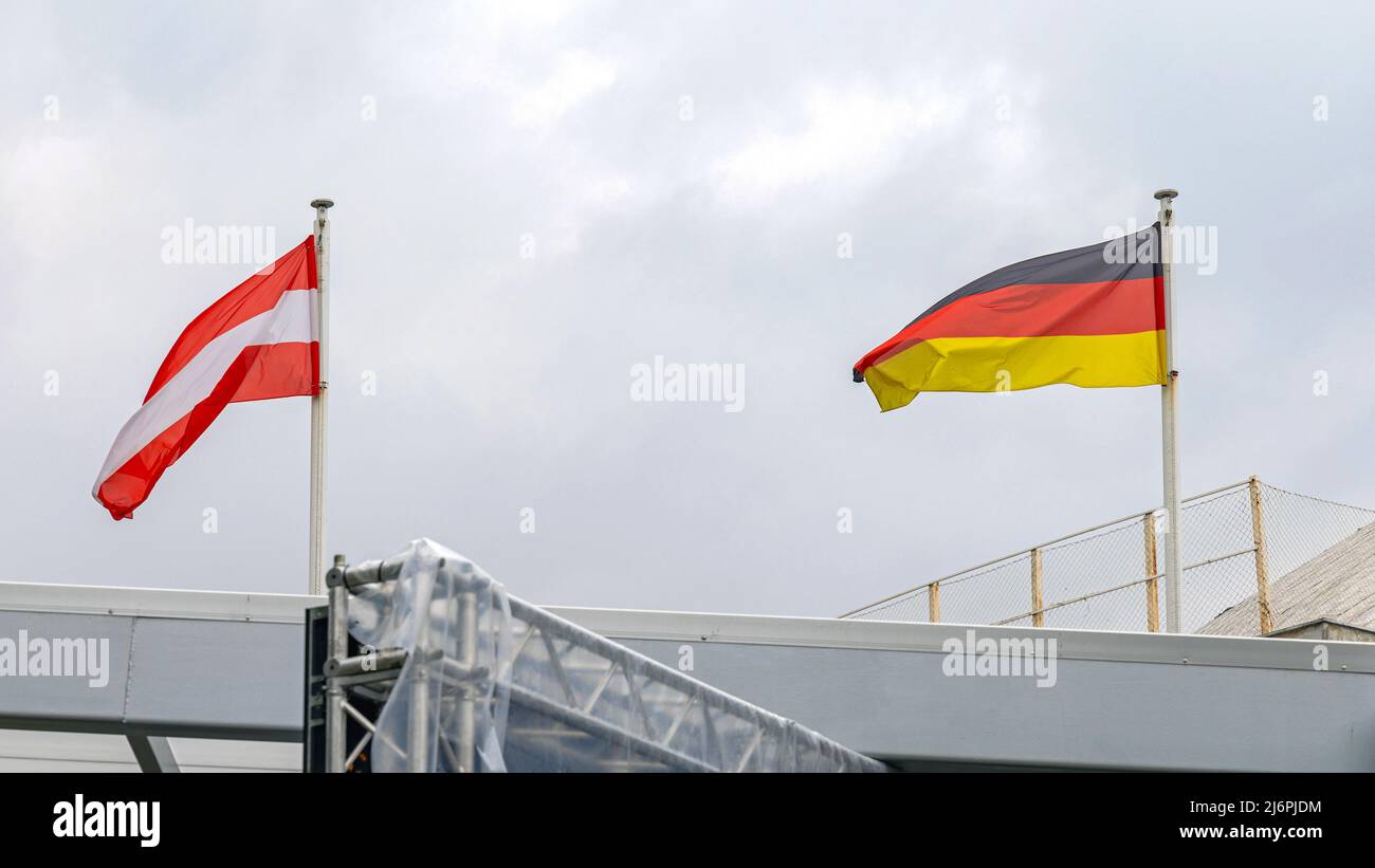 Repubblica d'Austria e Germania bandierano insieme a Cloudy Sky Foto Stock