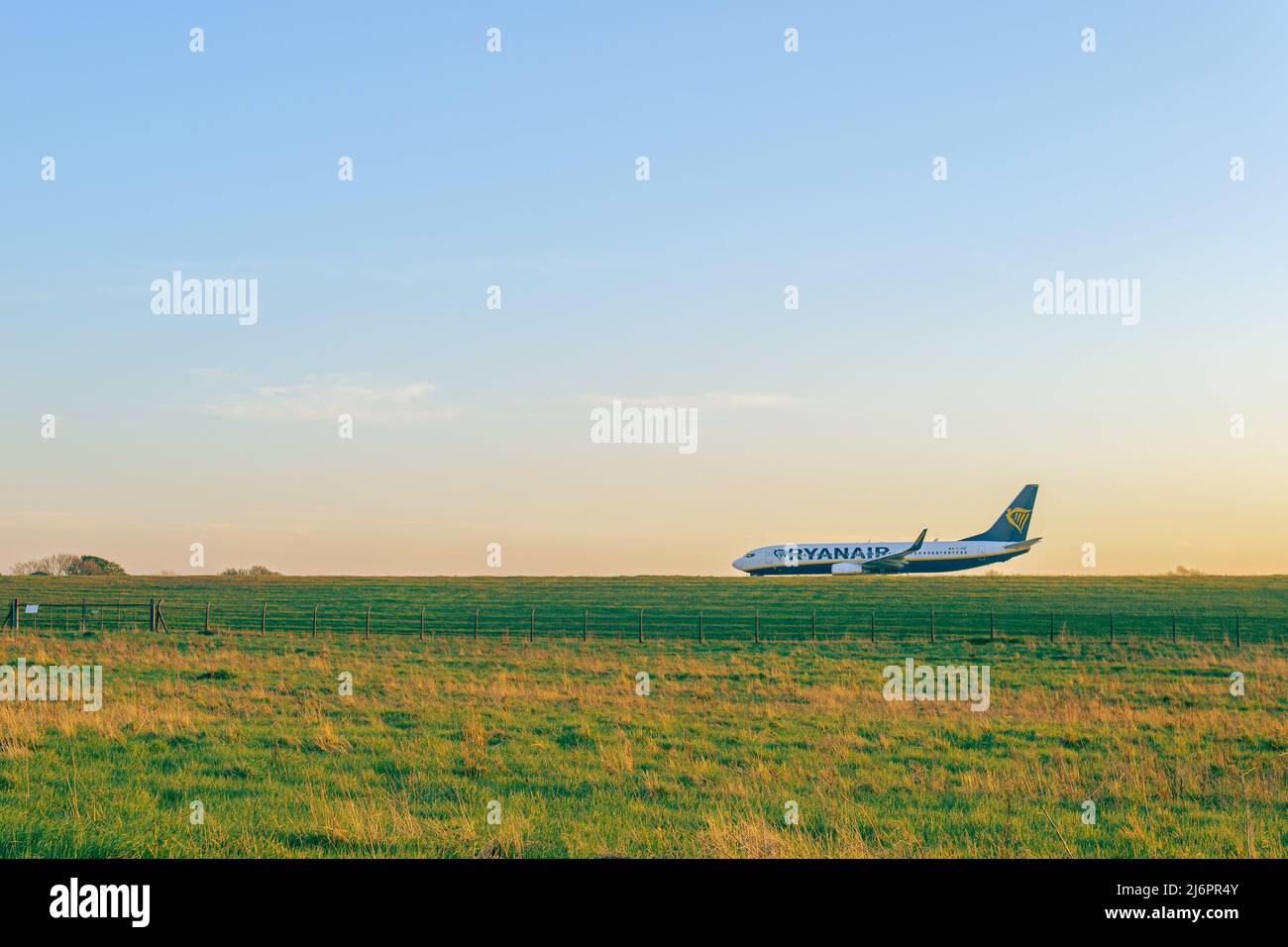Aereo Ryanair che decollo dalla pista dell'Aeroporto Internazionale Leeds Bradford. Un unico aereo sulla pista al tramonto. Foto Stock