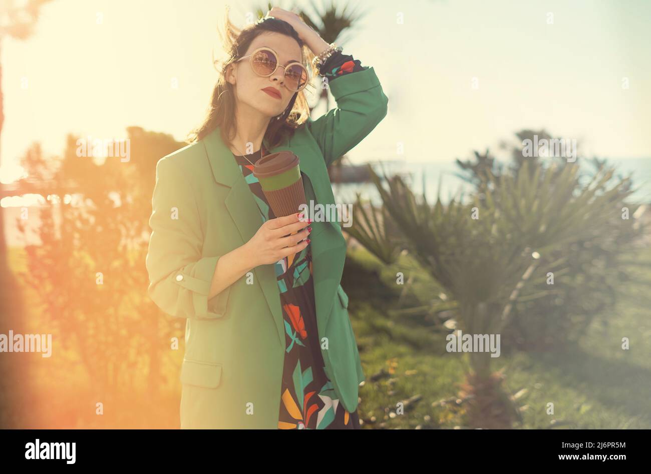 Donna all'aperto che tiene una tazza di caffè di bambù per andare Foto Stock