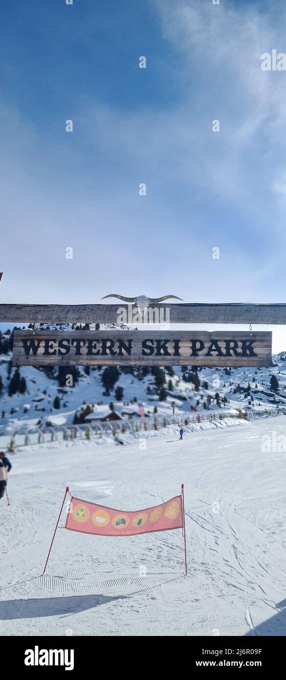 Courchevel, Francia - Febbraio 3 2022: Cartello di ingresso in legno americano con cranio di stambecco al 'Western Ski Park' sul pendio di Courchevel, Francia Foto Stock