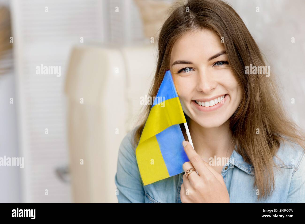 Libera sorridente ragazza che tiene bandiera Ucraina nelle sue mani, chiedendo la pace. Patriot del suo paese. Prega per l'Ucraina. Lotta per la libertà. Fermare la guerra Foto Stock