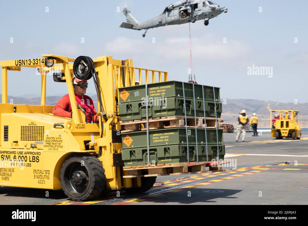 220502-N-CZ759-2054 SAN DIEGO (2 maggio 2022) – i marinai trasportano pallet di munizioni sul ponte di volo a bordo della nave d'assalto anfibio USS Tripoli (LHA 7), 2 maggio 2022. Tripoli sta conducendo operazioni di routine nella flotta USA 3rd. (STATI UNITI Foto Navy di Mass Communication Specialist 2nd Classe Theodore Quintana) Foto Stock