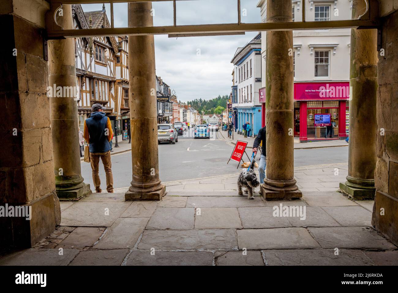 Le colonne di pietra del municipio e museo di Ludlow che guardano lungo la strada larga, Ludlow, Shropshire, Inghilterra. Foto Stock