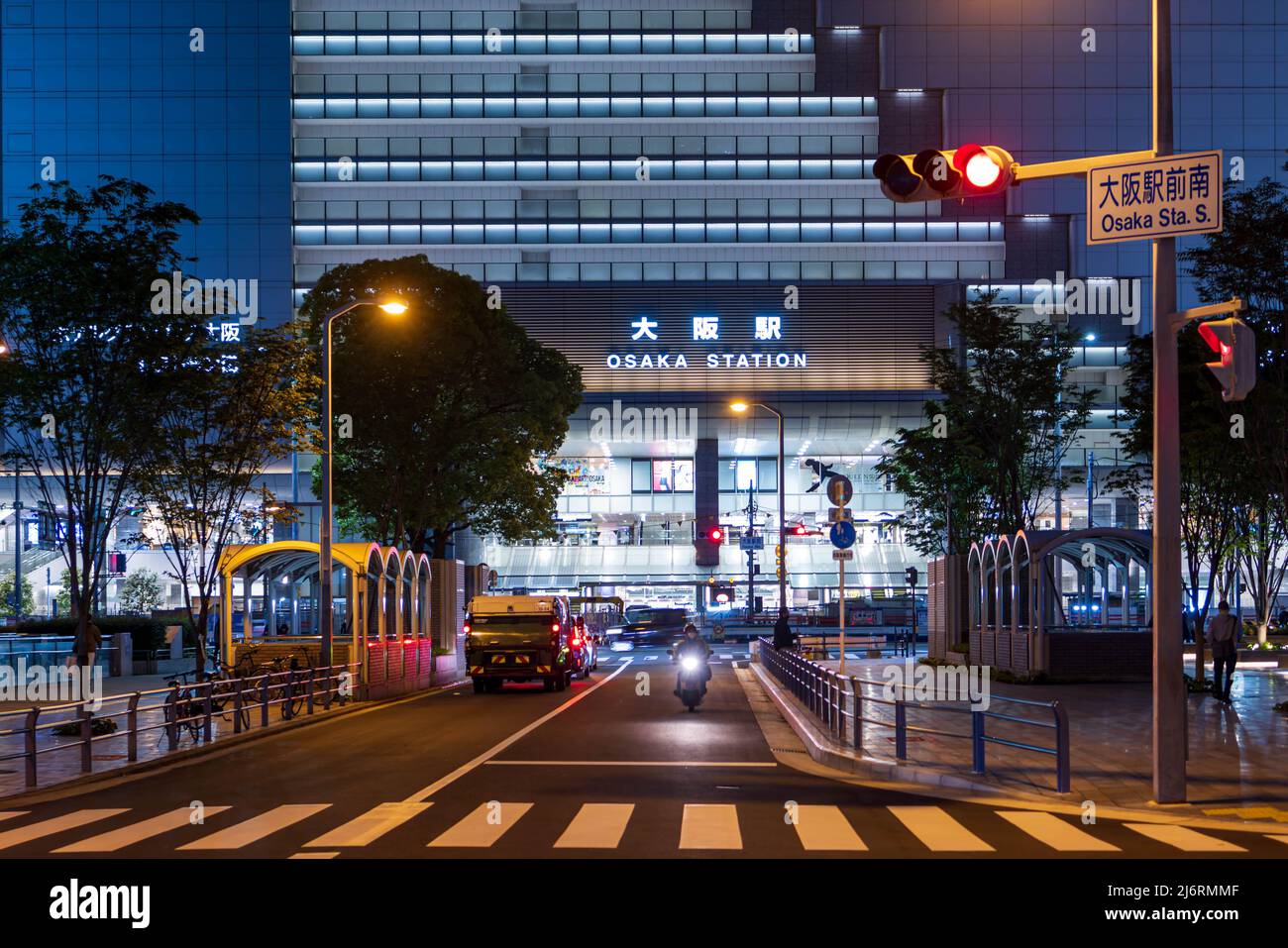 Osaka, Giappone - 1 maggio 2022: La moto singola si avvicina al semaforo di fronte alla stazione JR di Osaka di notte Foto Stock