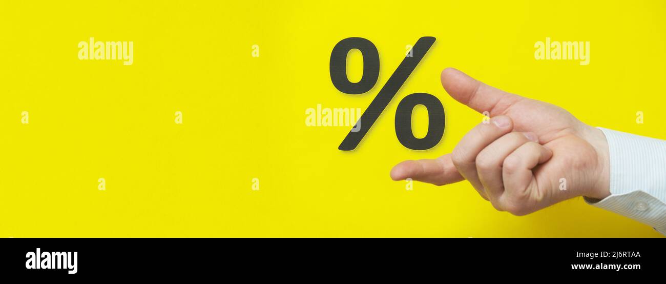 La mano mostra le percentuali su sfondo giallo. Foto Stock