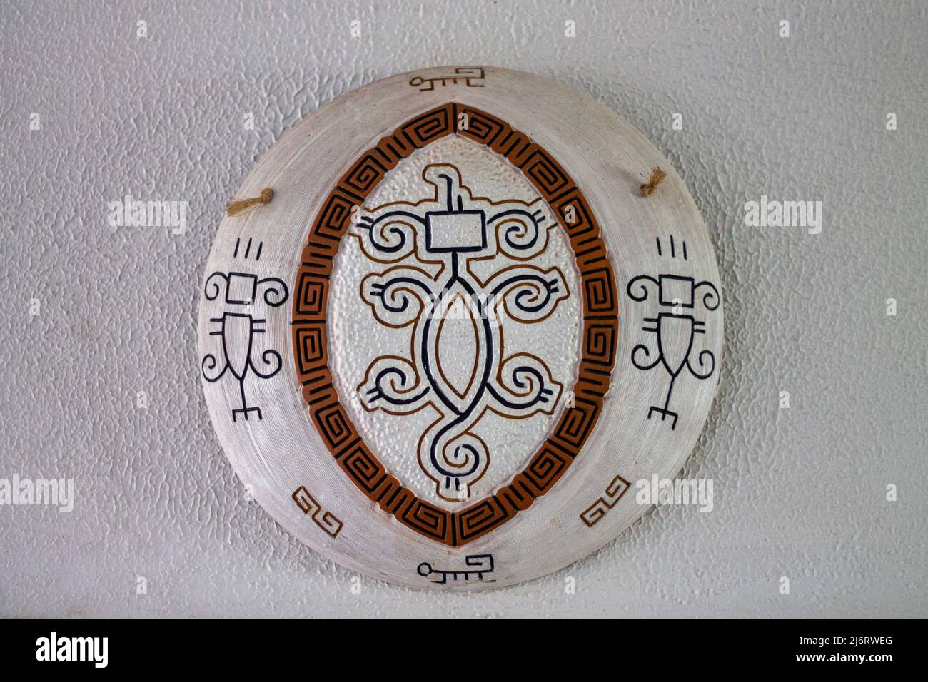 Decorazioni a parete, piatti di artigianato bianco con dettagli marroni e design nero amazon su una parete bianca testurizzata Foto Stock