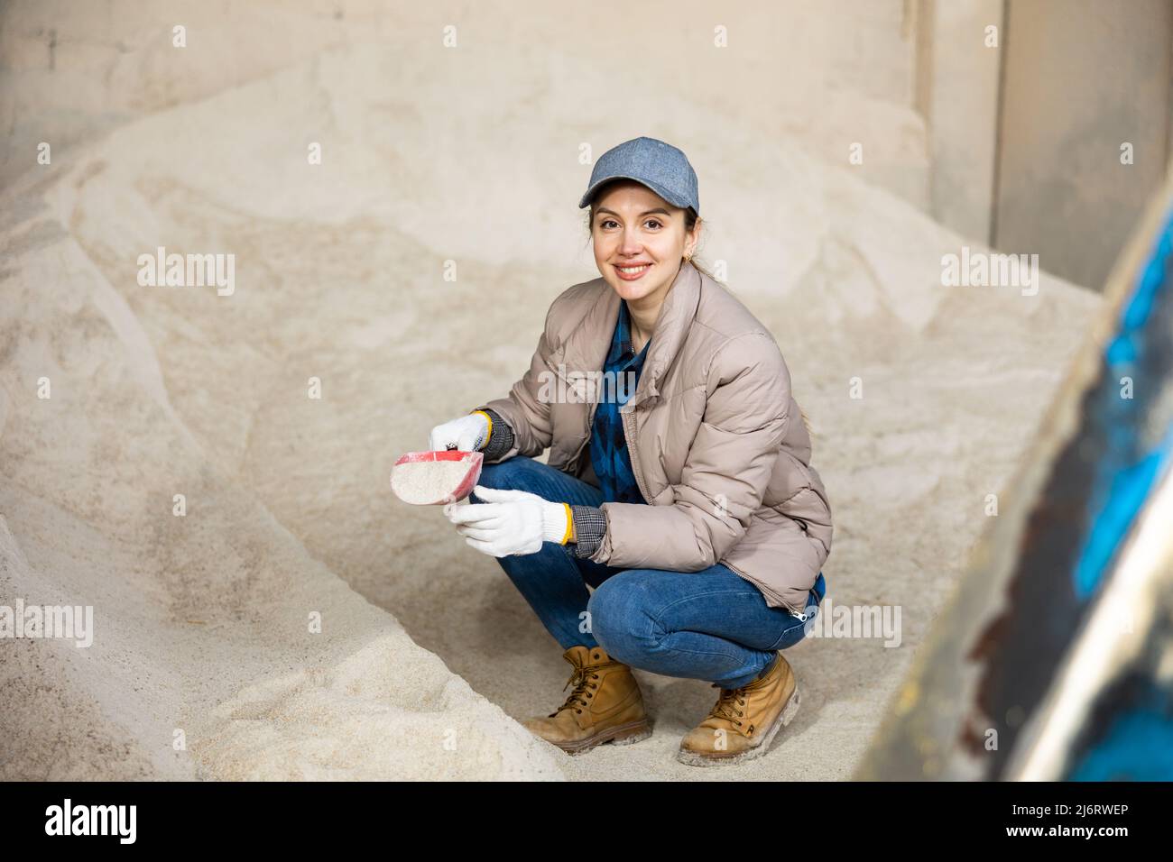 Donna contadina che squatting a mucchio di farina di mais Foto Stock