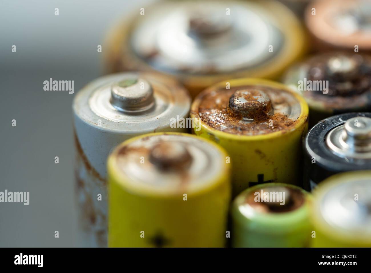 Primo piano della batteria usata con tracce di ruggine e corrosione. Concetto di rifiuti pericolosi elettronici Foto Stock