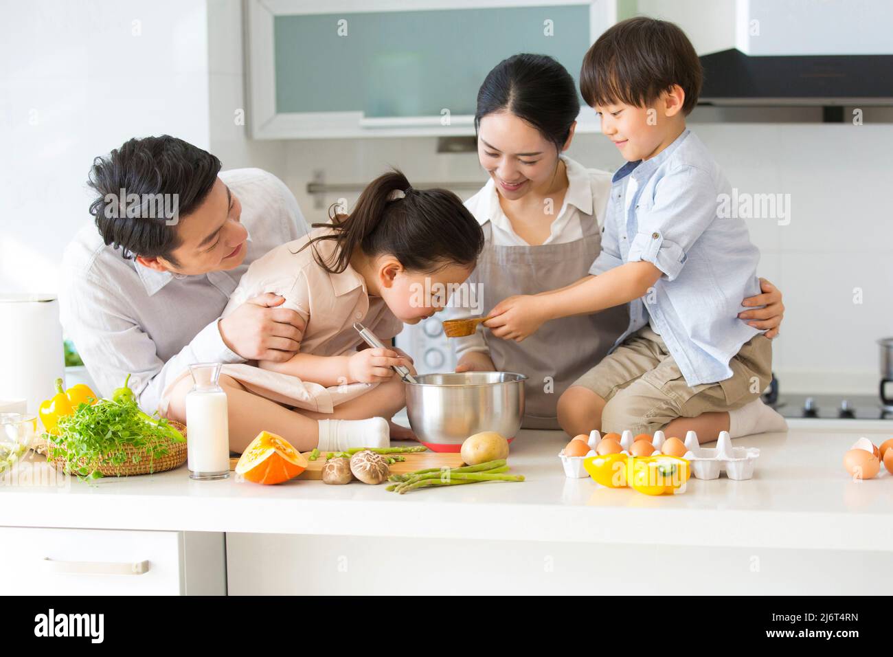 Famiglia cucina parentage. Una giovane famiglia di quattro cuochi pranzo insieme in cucina. - foto di scorta Foto Stock