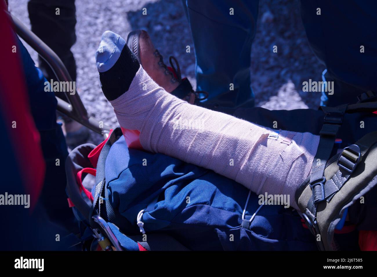 Il servizio di soccorso in montagna fornisce il pronto soccorso a chi ha la gamba rotta Foto Stock