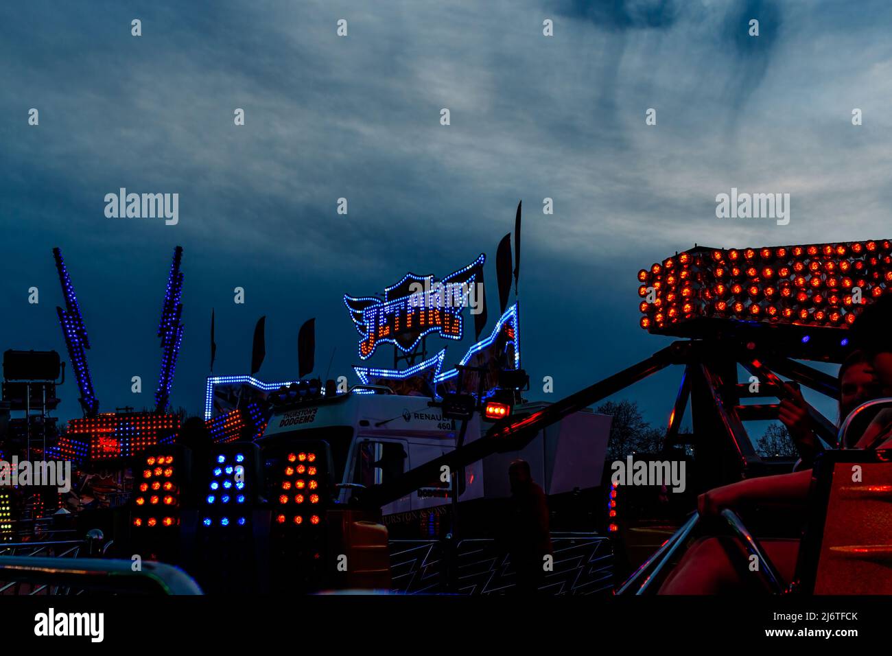 Le luci blu e rosse del funfair Jetfire illuminano il cielo notturno. Foto Stock