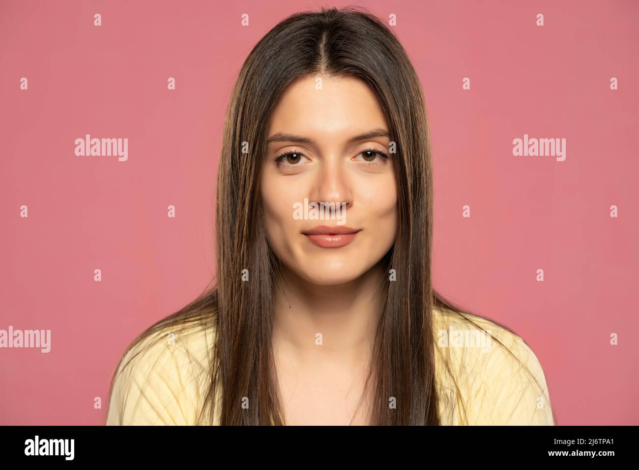 Ritratto di una giovane bella donna su sfondo rosa Foto Stock