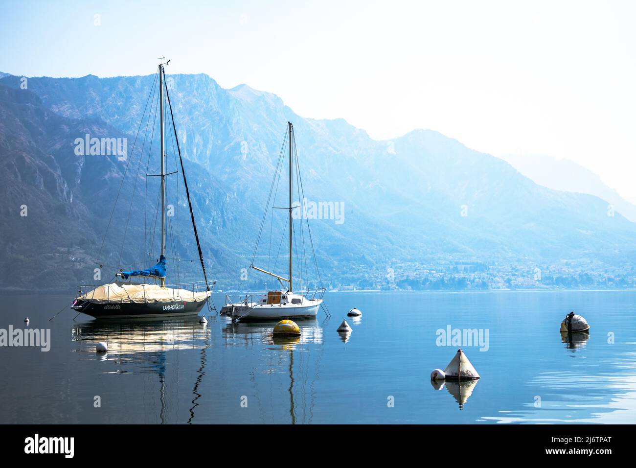 Due barche al Lago di Como Lago di Camo sul blu un cielo limpido e sfocato montagne in lontananza, paradiso a Bellagio, Como, Lombardia, Italia Foto Stock