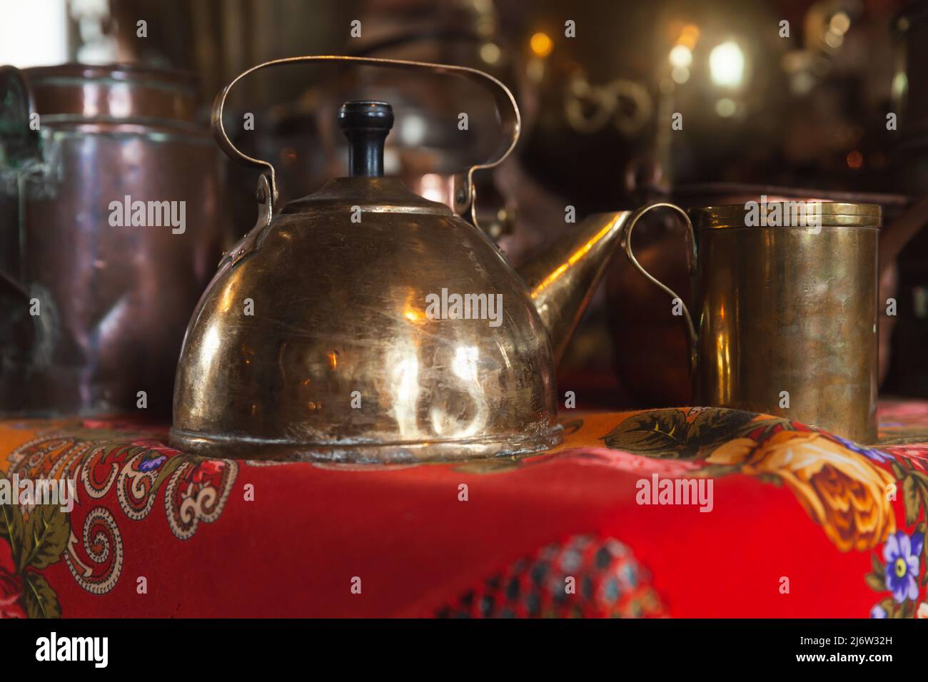 il bollitore vintage in rame si trova su un tavolo vicino alla tazza, foto ravvicinata con soft focus selettivo Foto Stock