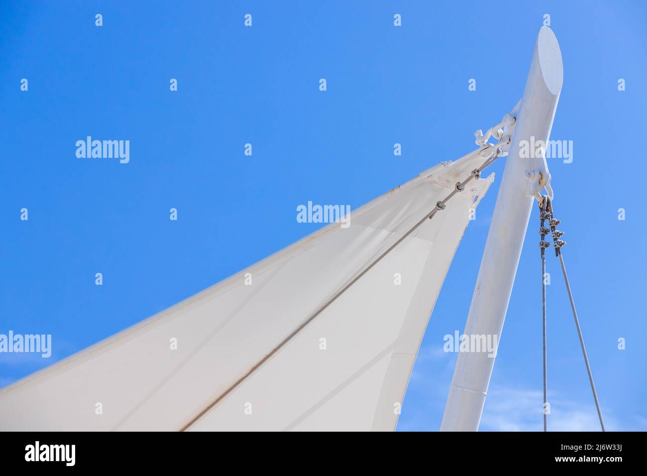 Tenda bianca a forma di vela sotto il cielo blu, sfondo del resort sulla spiaggia Foto Stock