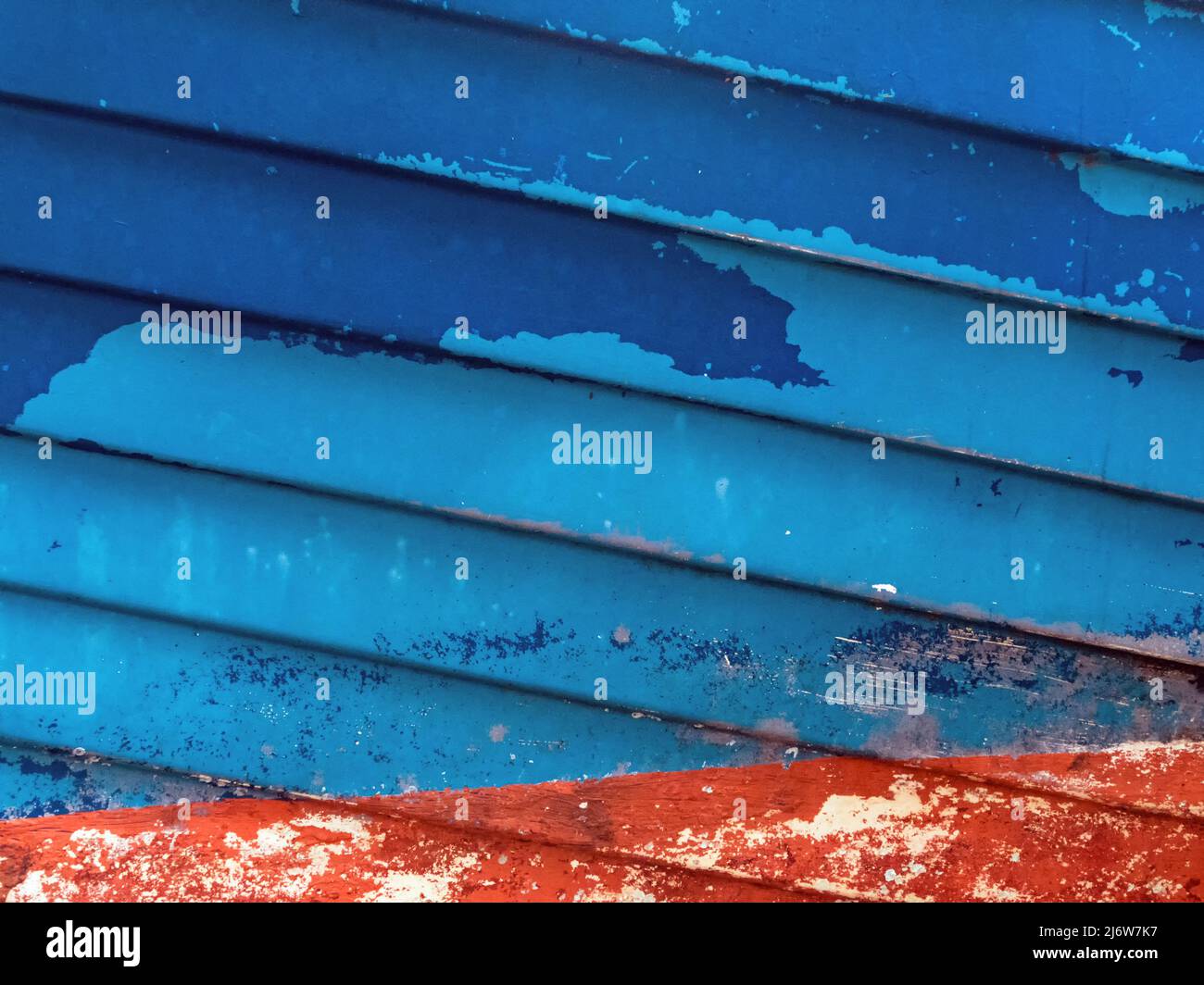 Immagine astratta dello scafo di una nave di colore rosso e blu con vernice da peeling Foto Stock