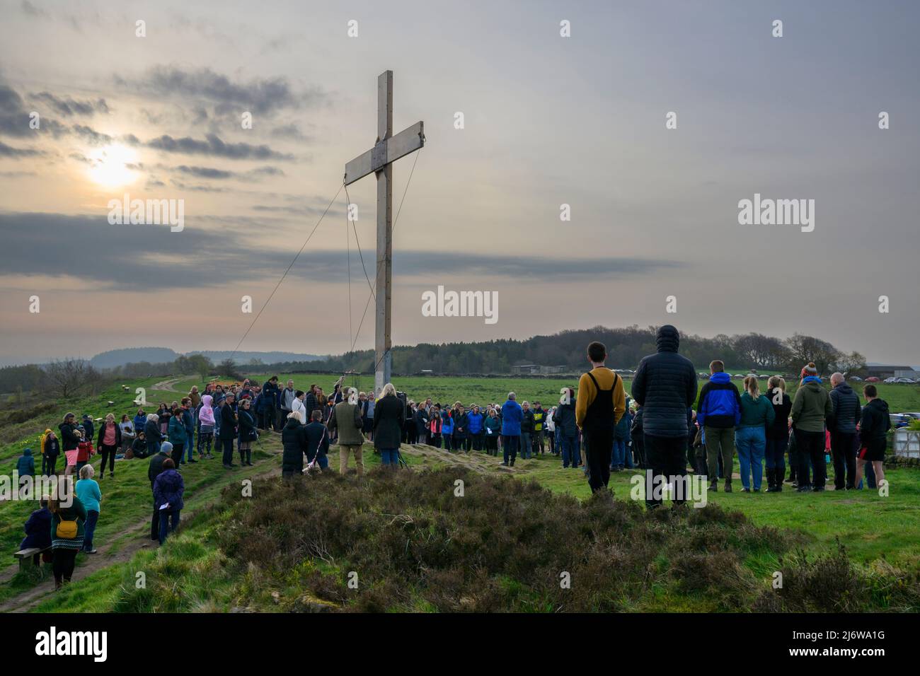 La folla della Congregazione si è riunita in cima alla collina per il tradizionale servizio dell'alba della Domenica di Pasqua da un'alta croce di legno - il Chevin, Otley, West Yorkshire Inghilterra UK. Foto Stock