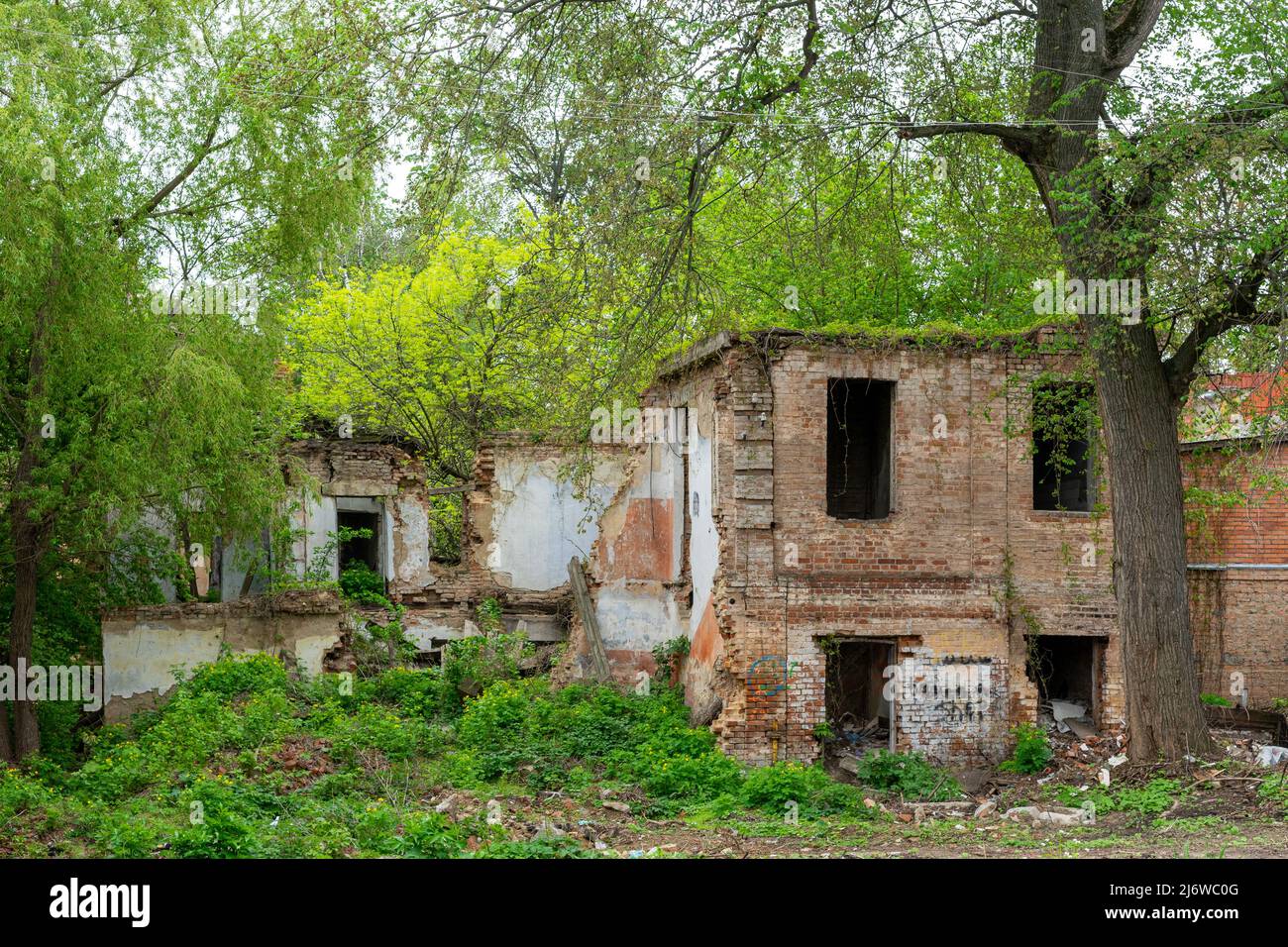 Vecchia casa in mattoni rossi dilapidati senza finestre e tetto Foto Stock