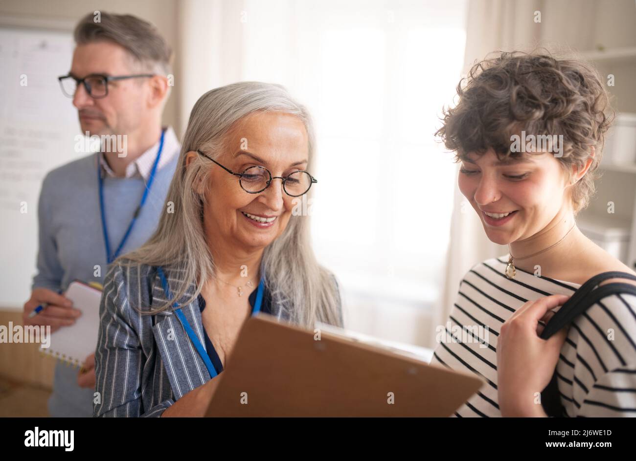 Impiegato del centro di lavoro che aiuta la giovane donna a compilare il modulo per trovare un lavoro. Foto Stock