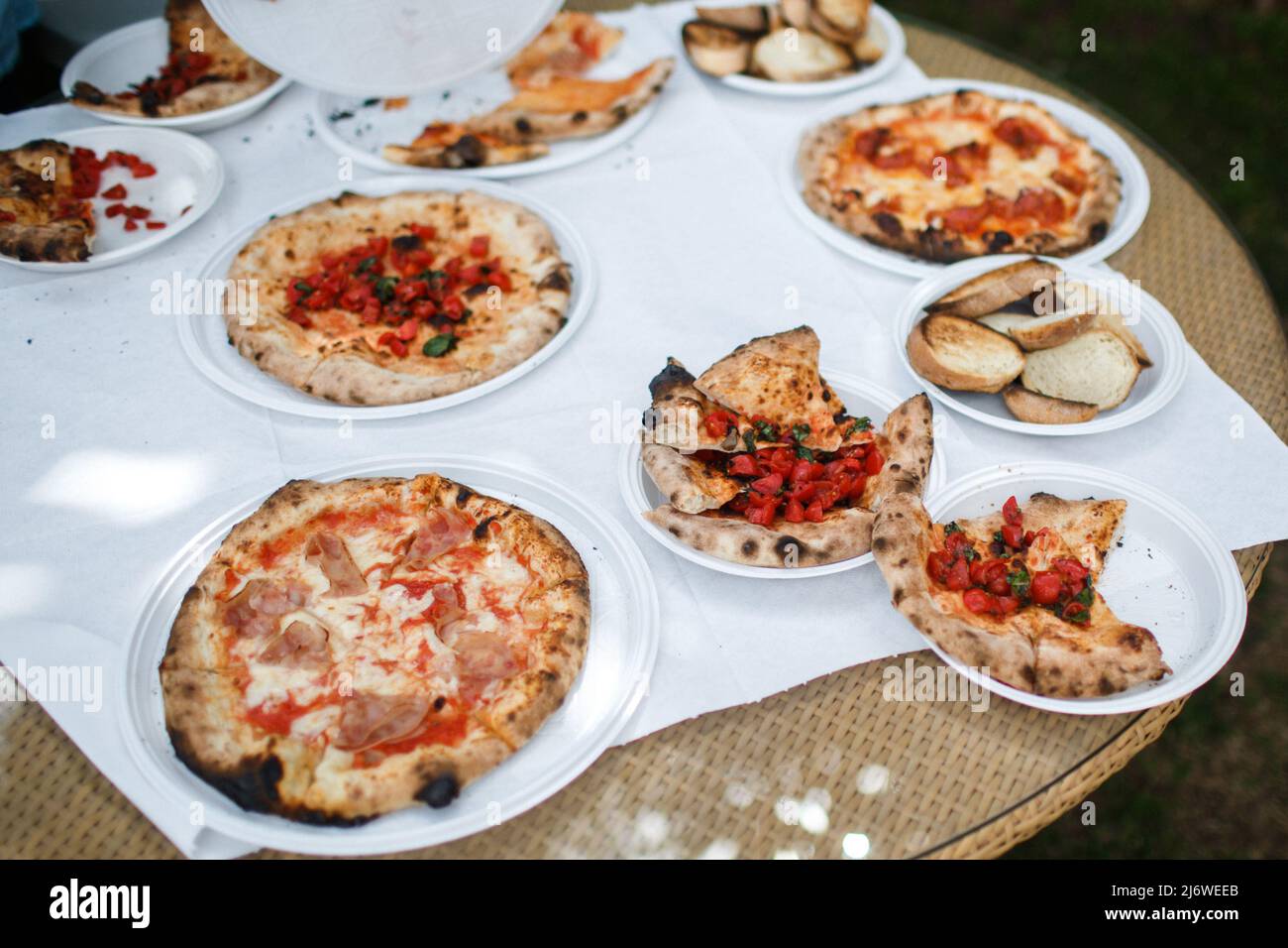 Pizze sul tavolo in piatti di plastica. Foto Stock