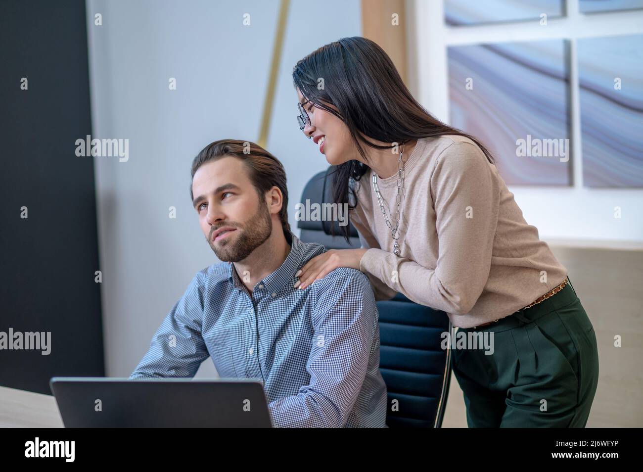 Assistente che dà un massaggio rilassante al suo capo Foto Stock