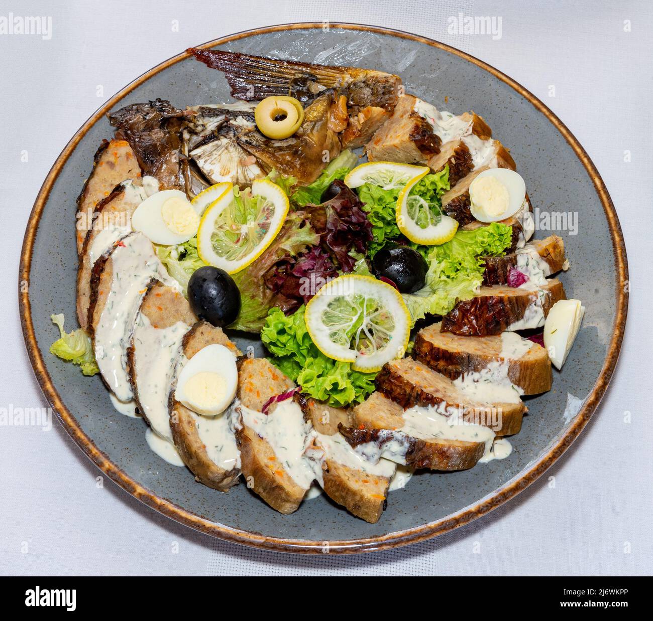Carpa ripiena. Il pesce è decorato con verdure, frutta e uova di quaglia Foto Stock
