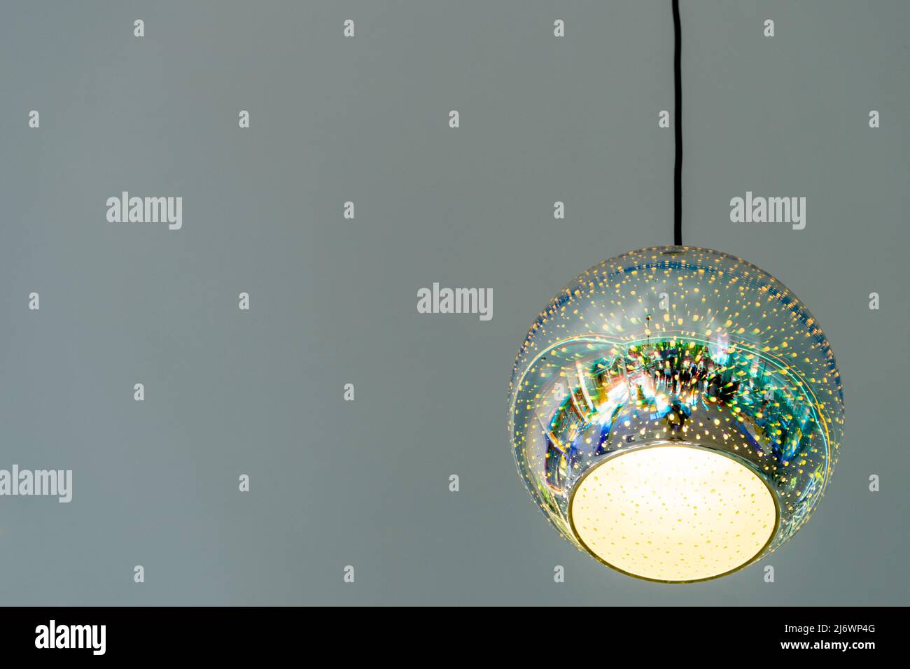 Lampadario moderno a forma di palla su sfondo grigio. Spazio di copia Foto Stock