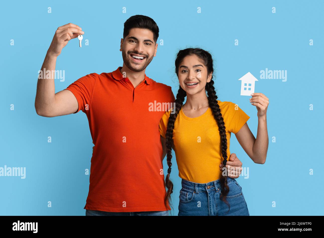 Concetto di alloggio. Sorridente coppia araba che tiene Home Keys e Paper House icona Foto Stock