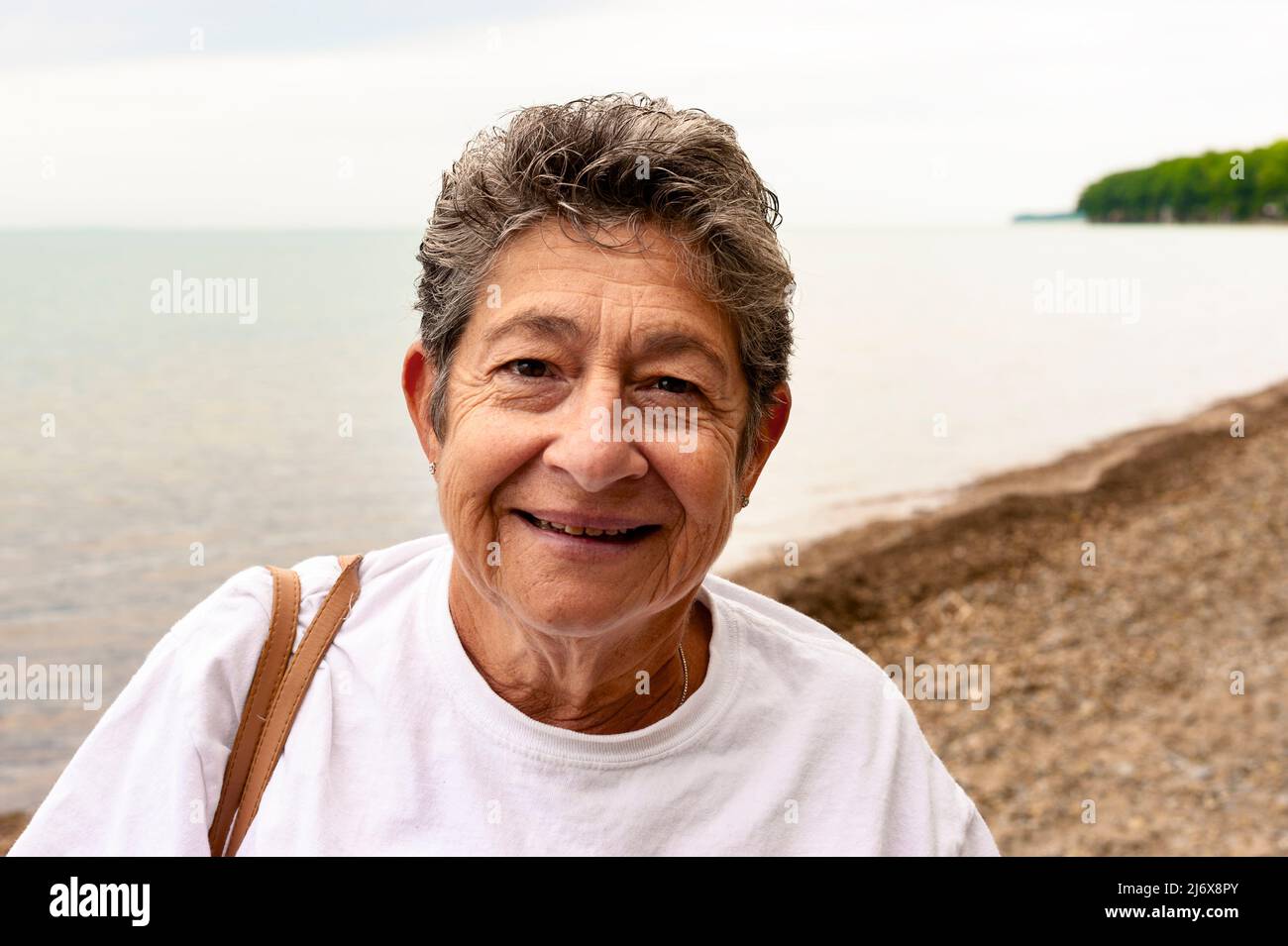 Donna anziana lungo le rive del lago Erie vicino Buffalo, New York, USA. Foto Stock