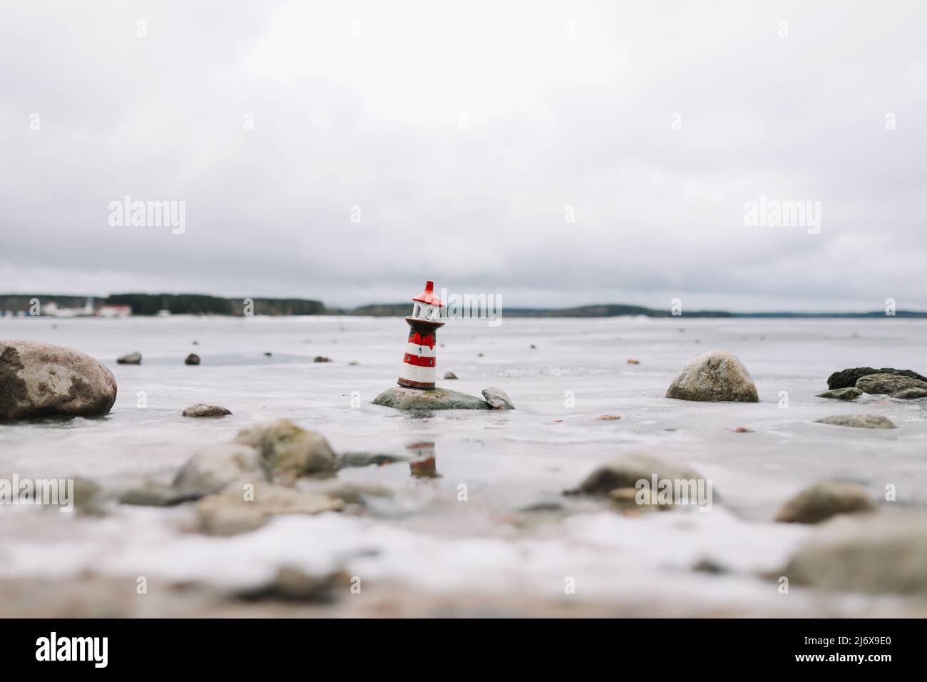 Mare d'inverno ghiacciato con faro decorativo. Stile di vita nautico. Inverno, Mare, Viaggi, avventura, vacanze e vacanza concetto. Viaggia nel 2021 Foto Stock