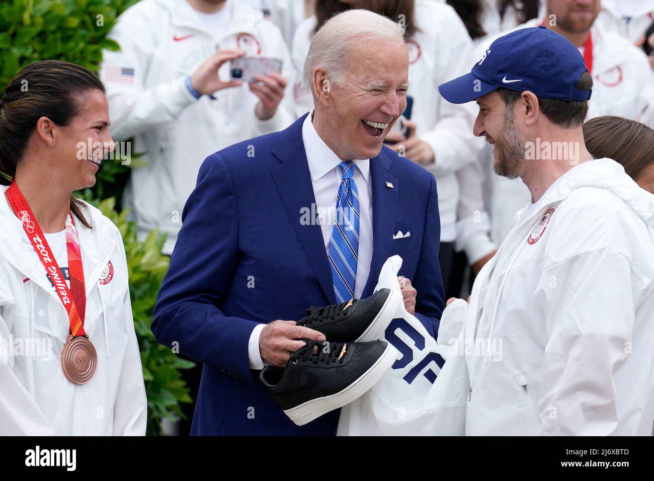 Il presidente degli Stati Uniti Joe Biden è presentato scarpe e la giacca di squadra dal curler John Shuster e dal pattinatore di velocità Brittany Bowe, mentre dà il benvenuto al team olimpico USA sul prato del sud della Casa Bianca a Washington il 4 maggio 2022. Foto di Yuri Gripas/ABACAPRESS.COM Foto Stock