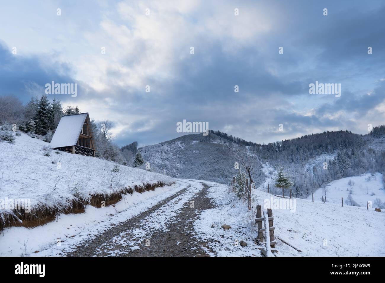 Bellissimo paesaggio invernale di montagna. Strada di montagna sale vicino alla casa in costruzione Foto Stock