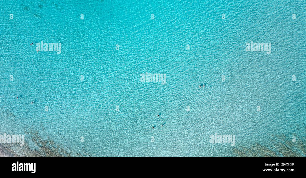 La gente nuota in blu turchese trasparente mare acqua aerea drone vista. Tempo libero estivo sotto il sole greco. Giorno di sole, Grecia destinazione di viaggio Foto Stock