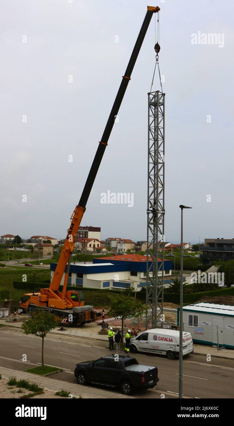 La seconda sezione dell'albero di una gru a torre è stata sollevata in posizione da una gru montata su autocarro in un cantiere Santander Cantabria Spagna Foto Stock