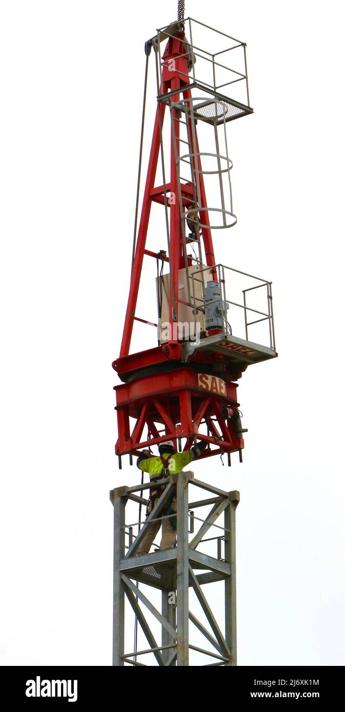 Una gru mobile che solleva l'unità girevole con un operatore di costruzione che la guida in posizione sull'albero di una gru a torre Santander Cantabria Spagna Foto Stock