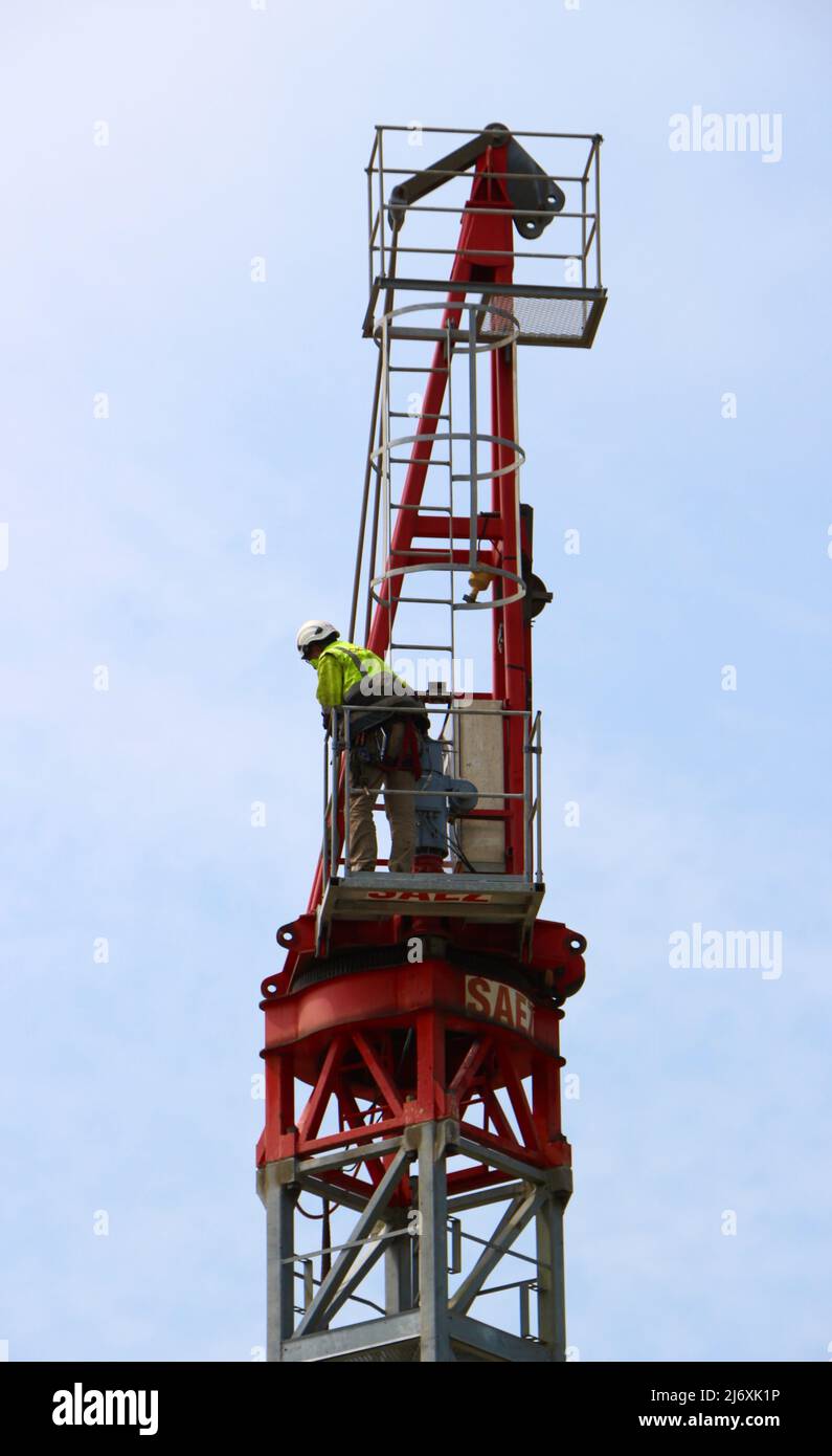 Un operaio di costruzioni attende la sezione successiva di una gru a torre che viene assemblata Santander Cantabria Spagna Foto Stock