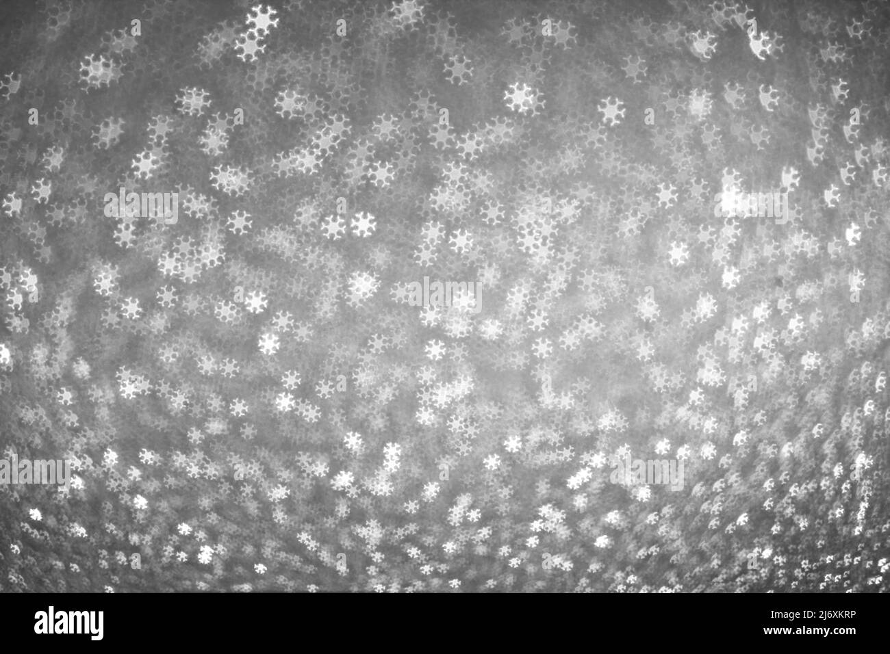 Il bokeh bianco si illumina sotto forma di fiocchi di neve su sfondo grigio argento. Inverno sfondo di Natale Foto Stock