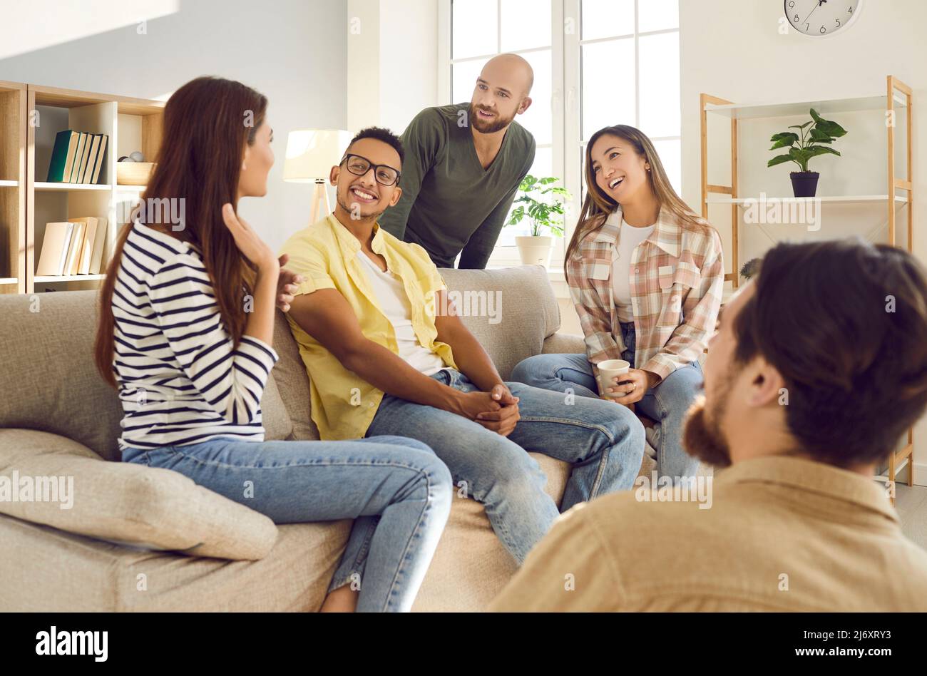 Gruppo di giovani popple si divertono a comunicare tra loro durante l'incontro a casa. Foto Stock