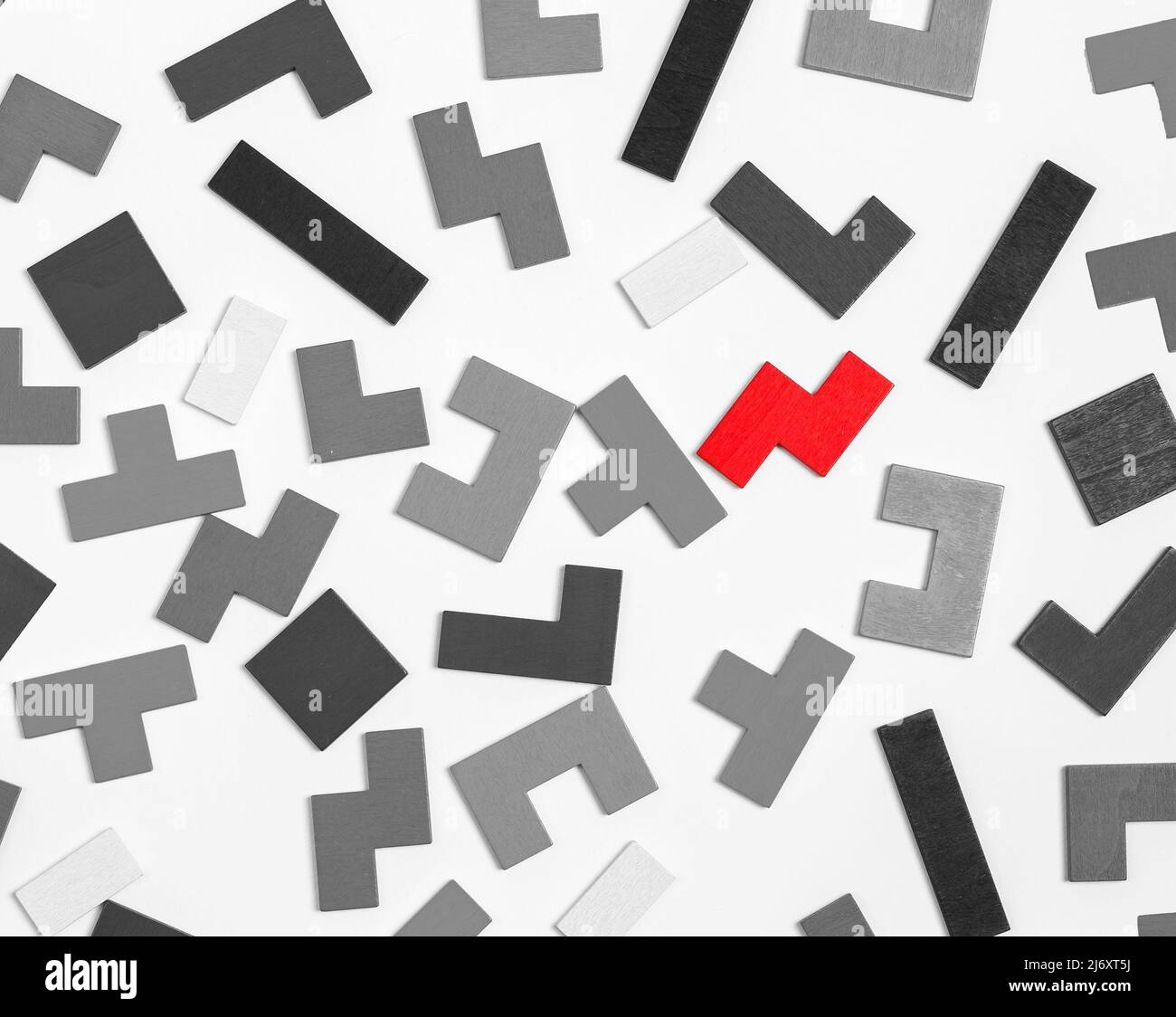 pezzi di puzzle bianco e nero con uno rosso eccezionale. Unicità, standing fuori dalla folla, concetto di individualità. Foto di alta qualità Foto Stock