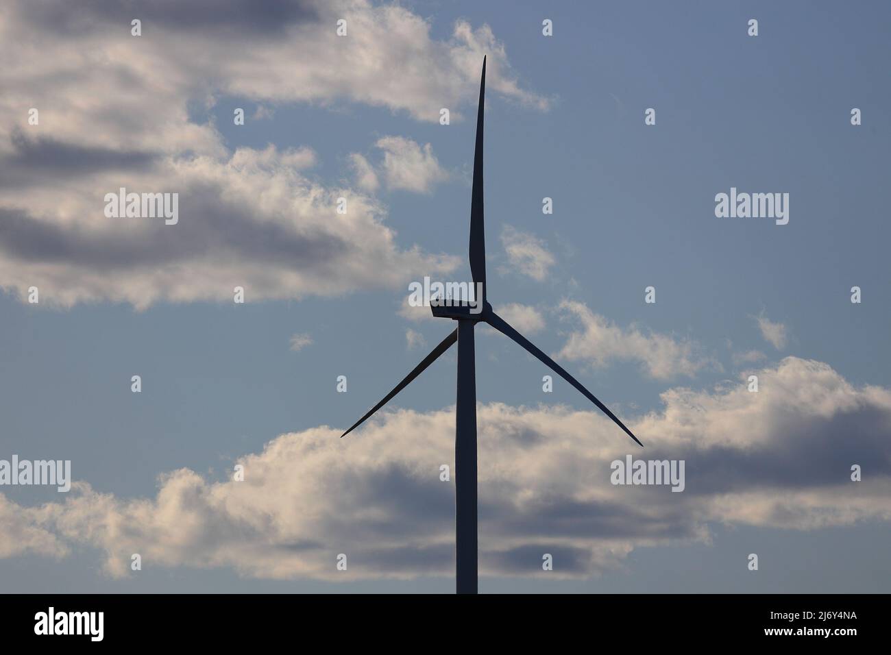 Turbina eolica con sfondo cielo blu nuvoloso Foto Stock