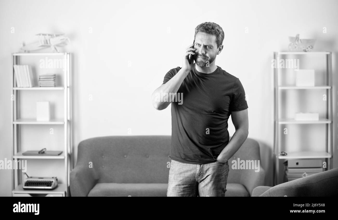 uomo maturo che parla al telefono all'interno dell'ufficio, comunicazione Foto Stock