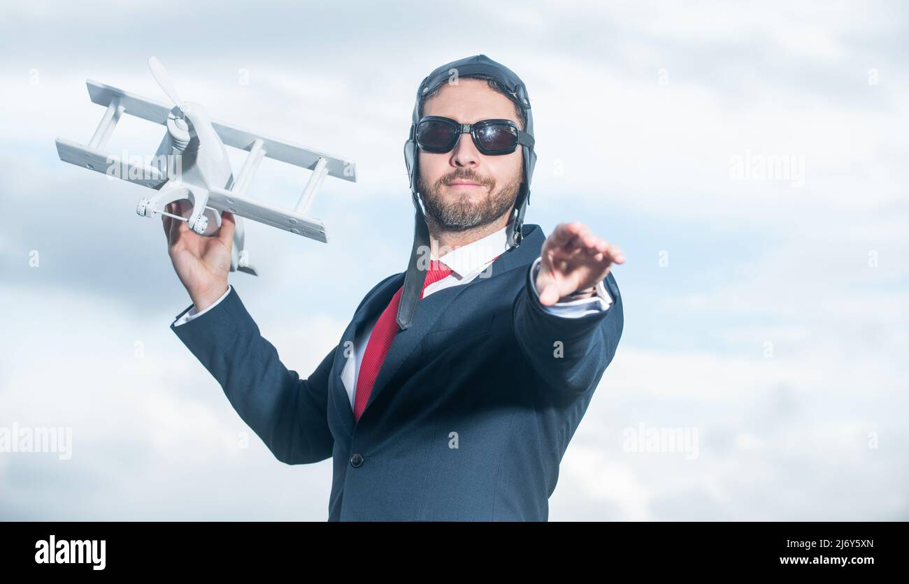 uomo d'affari in abito e cappello pilota lancia giocattolo aereo. ispirazione Foto Stock