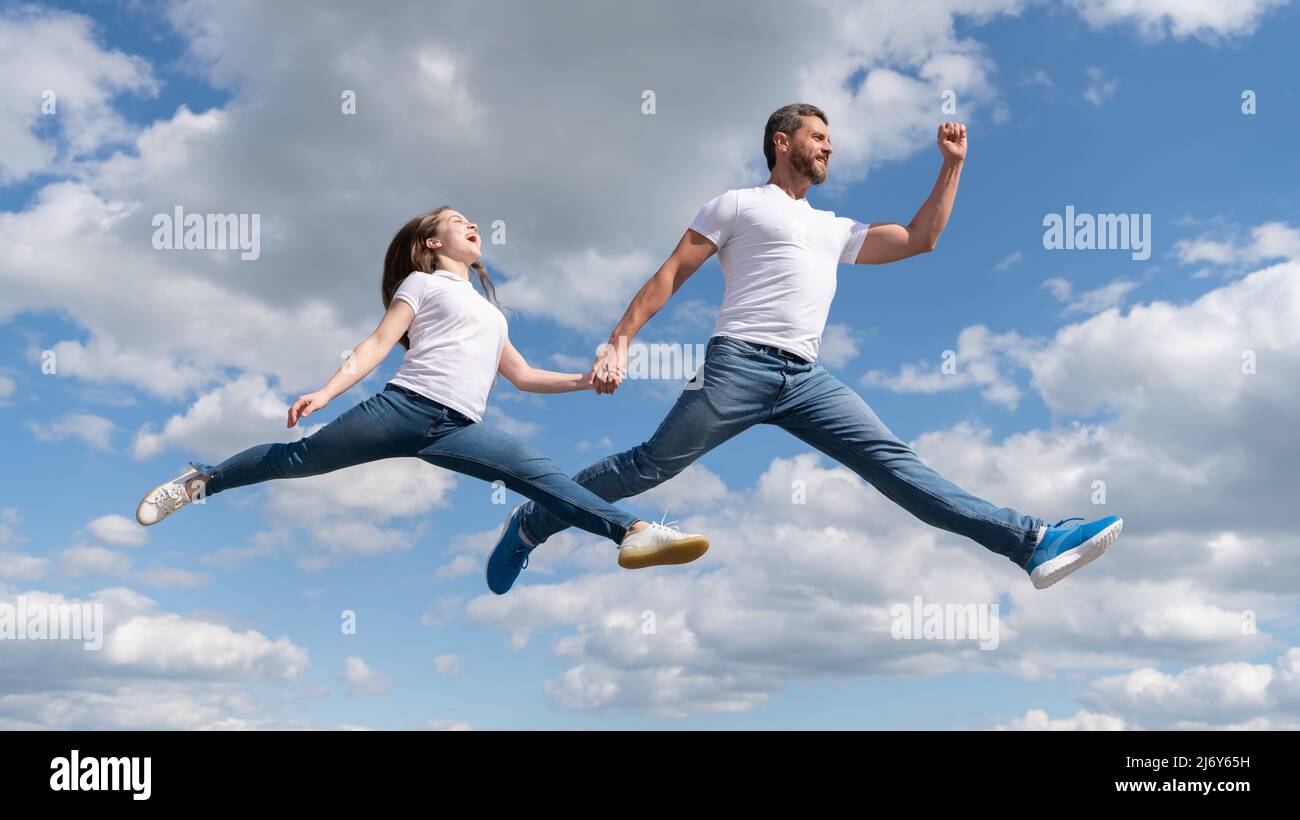 felice padre e figlia saltano nel cielo. stile di vita attivo Foto Stock