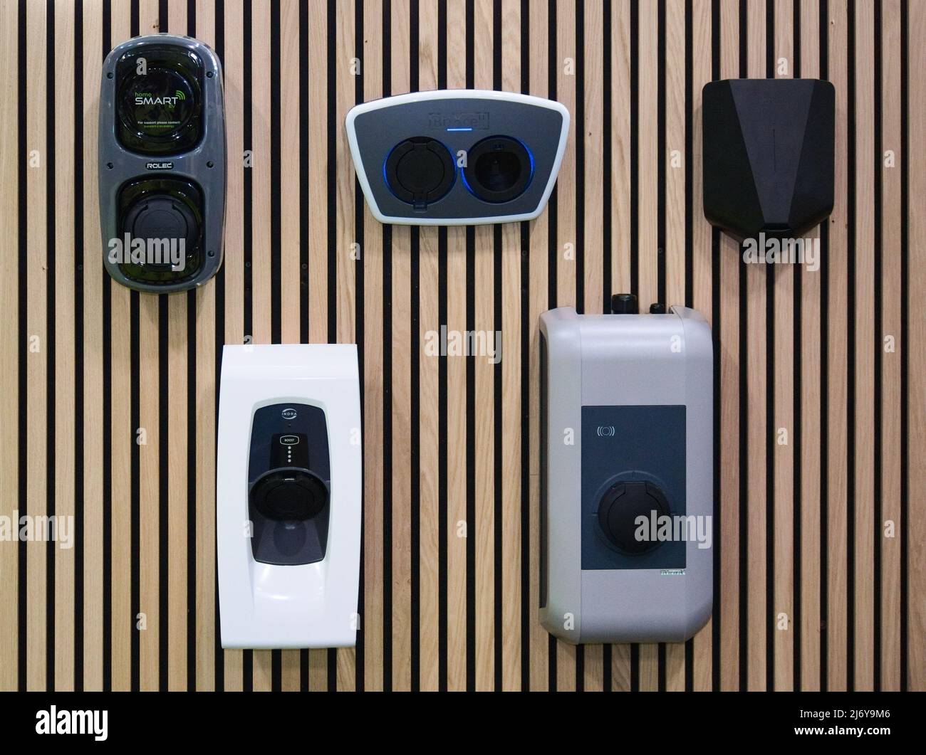 Una selezione di diversi caricabatteria per uso domestico per veicoli elettrici (EV) tipo 2, 7kW su una parete del display a pannelli di legno. Solo alcuni dei caricabatterie disponibili. Foto Stock
