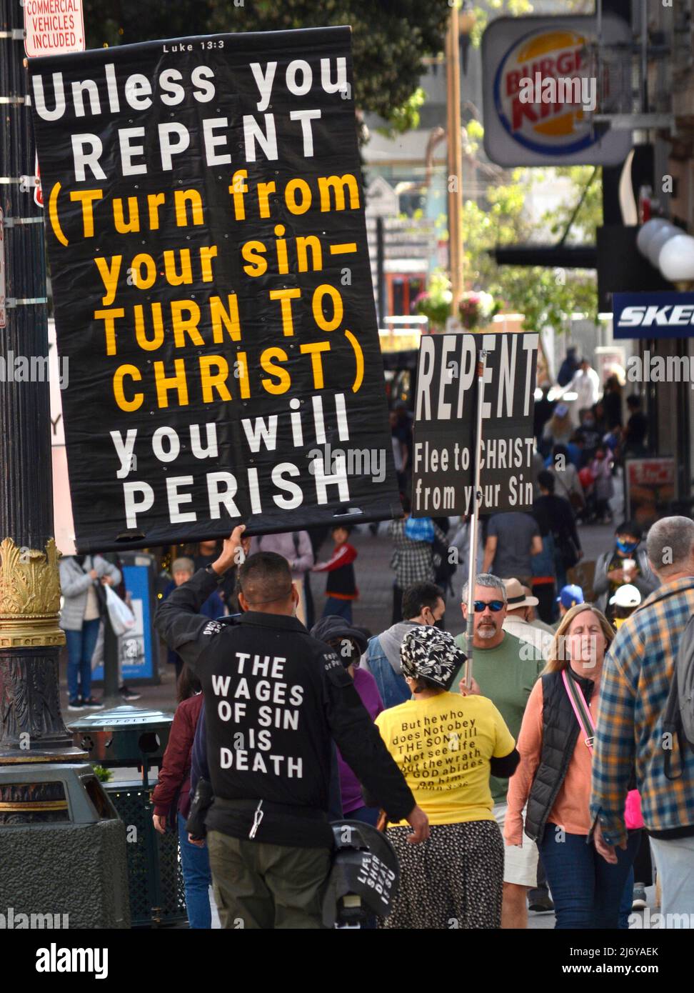 I cristiani evangelici con segni e un megafono camminano lungo un marciapiede a San Francisco, California, esortando le persone a pentirsi dei loro peccati. Foto Stock