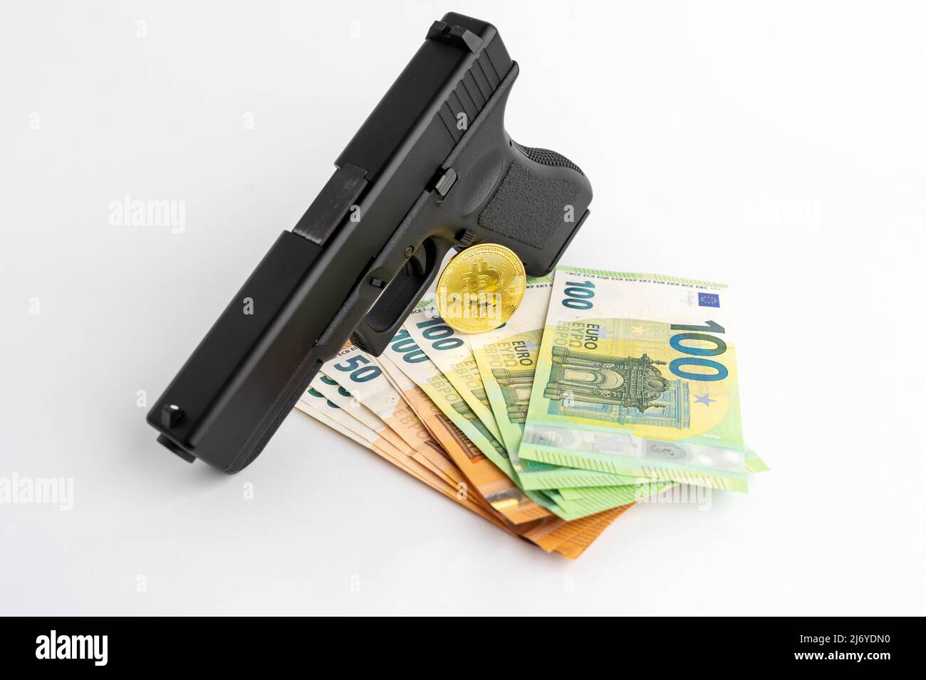 Banconote da pistola, Bitcoin e euro su sfondo bianco. Simboli di criminalità nel mondo reale e darknet. Denaro contante e BTC utilizzati come pagamento. Foto Stock